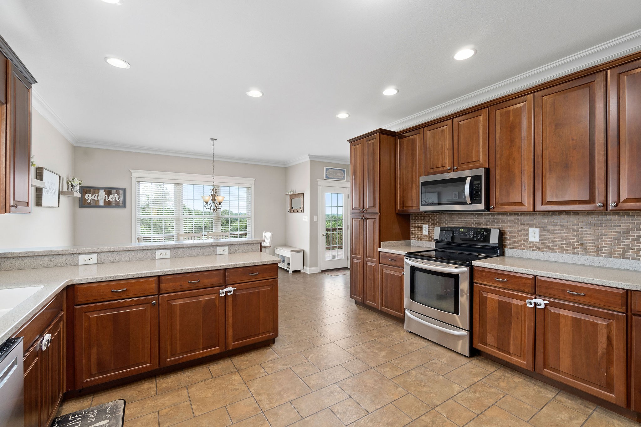 701 7 Mile Ferry Road Cunningham, TN 37052 - Photo 8 of 36 a large kitchen with stainless steel appliances granite countertop a stove top oven a sink dishwasher a dining table and chairs with wooden cabinets