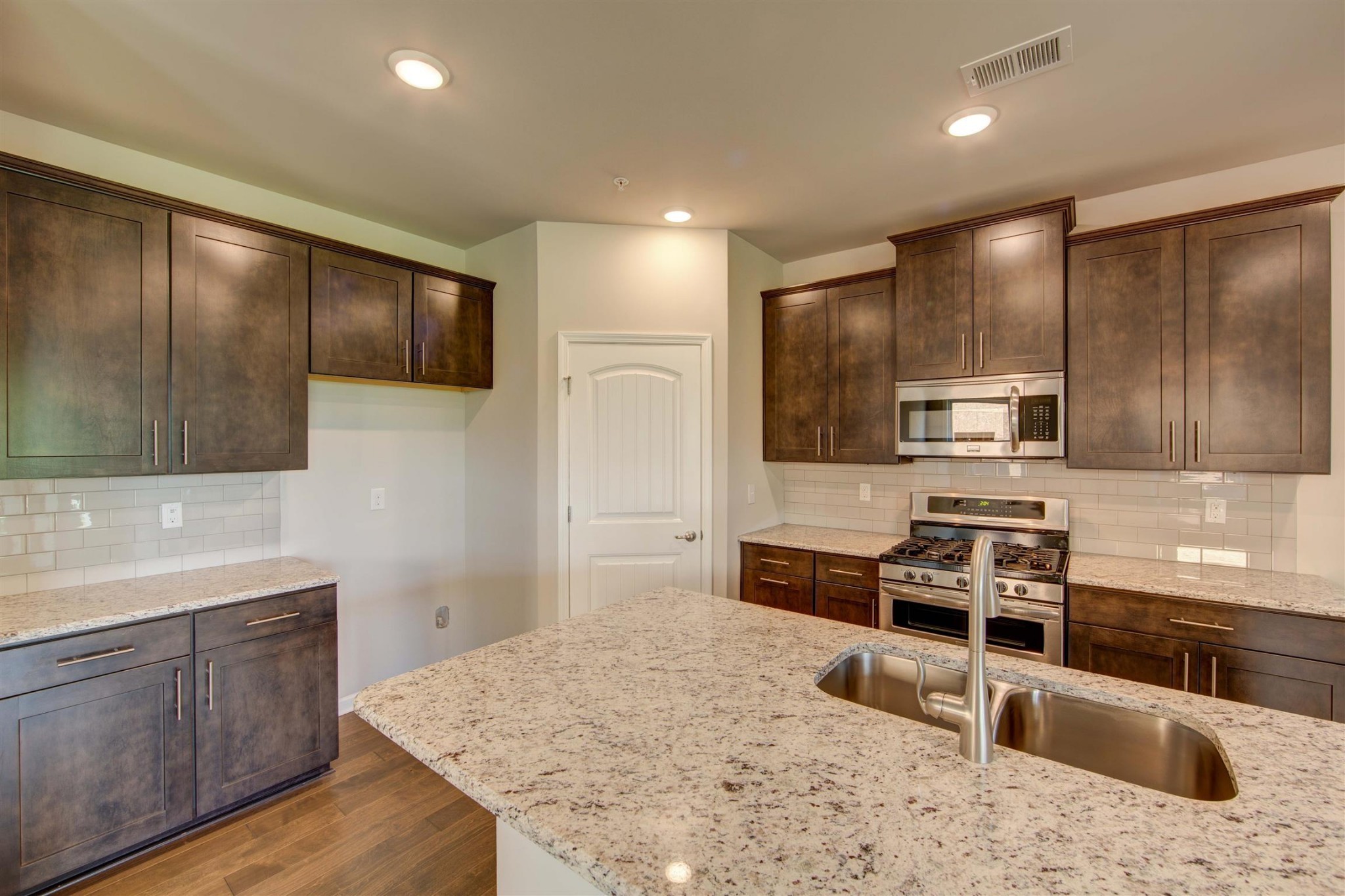 4343 Maxwell Road Antioch, TN 37013 - Photo 8 of 31 a kitchen with stainless steel appliances kitchen island granite countertop a stove a sink and a microwave