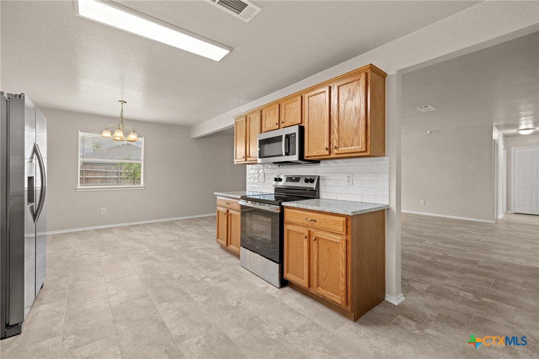 214 Timber Ridge Drive Nolanville, TX 76559 - Photo 13 of 31 a kitchen with stainless steel appliances granite countertop a stove a sink dishwasher a refrigerator and a microwave oven