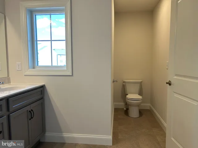a bathroom with a toilet a sink and a window