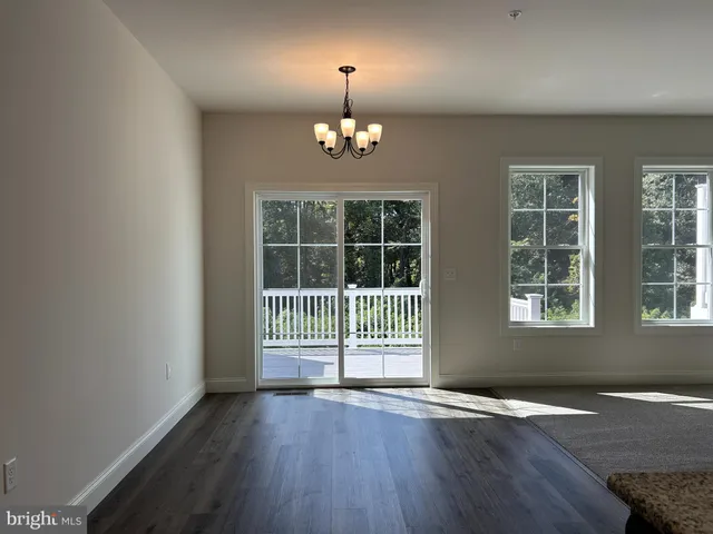 an empty room with wooden floor and a window