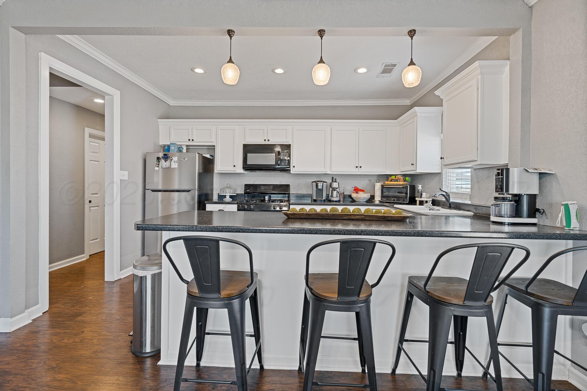 104 South Cherry Street Claude, TX 79019 - Photo 11 of 22 a kitchen with stainless steel appliances granite countertop a table chairs microwave and sink