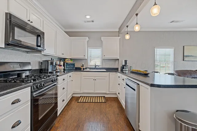 a kitchen with stainless steel appliances granite countertop a sink and cabinets