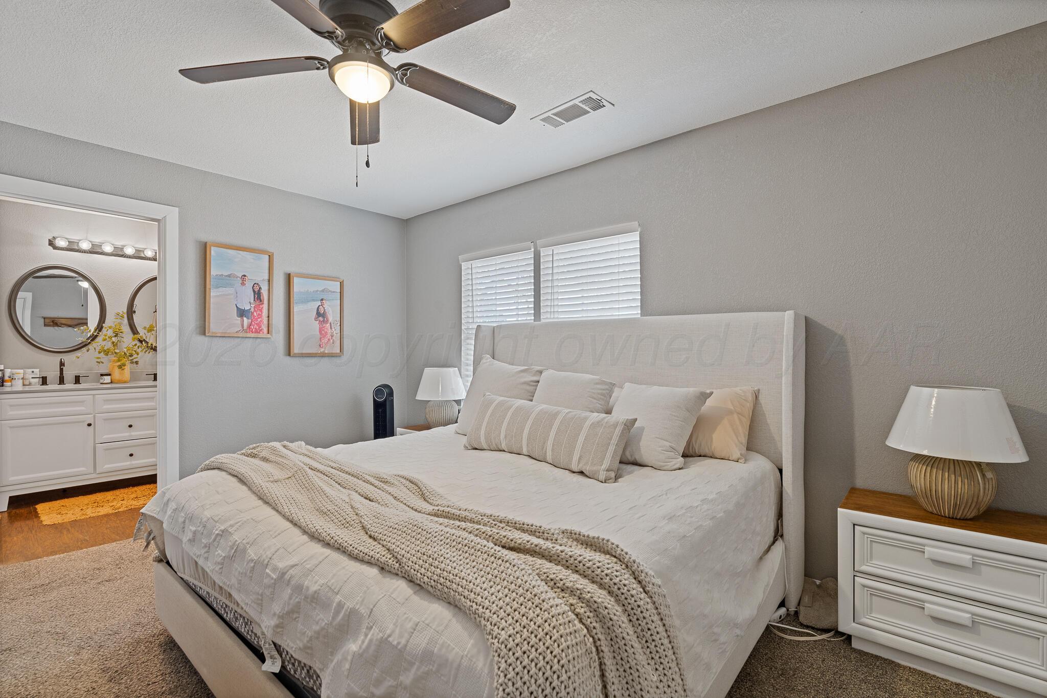104 South Cherry Street Claude, TX 79019 - Photo 18 of 22 a bedroom with a bed and a chandelier