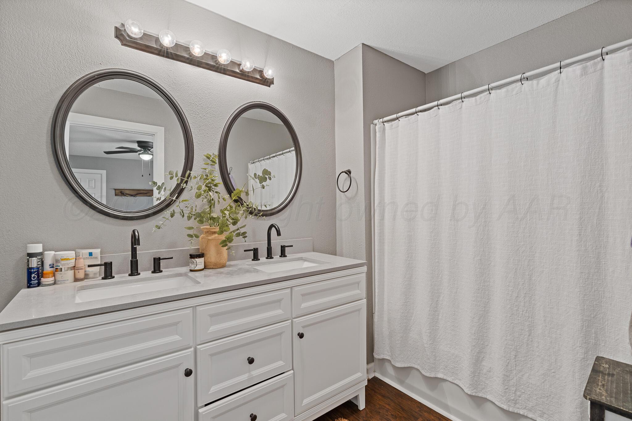 104 South Cherry Street Claude, TX 79019 - Photo 20 of 22 a bathroom with a double vanity sink and a mirror