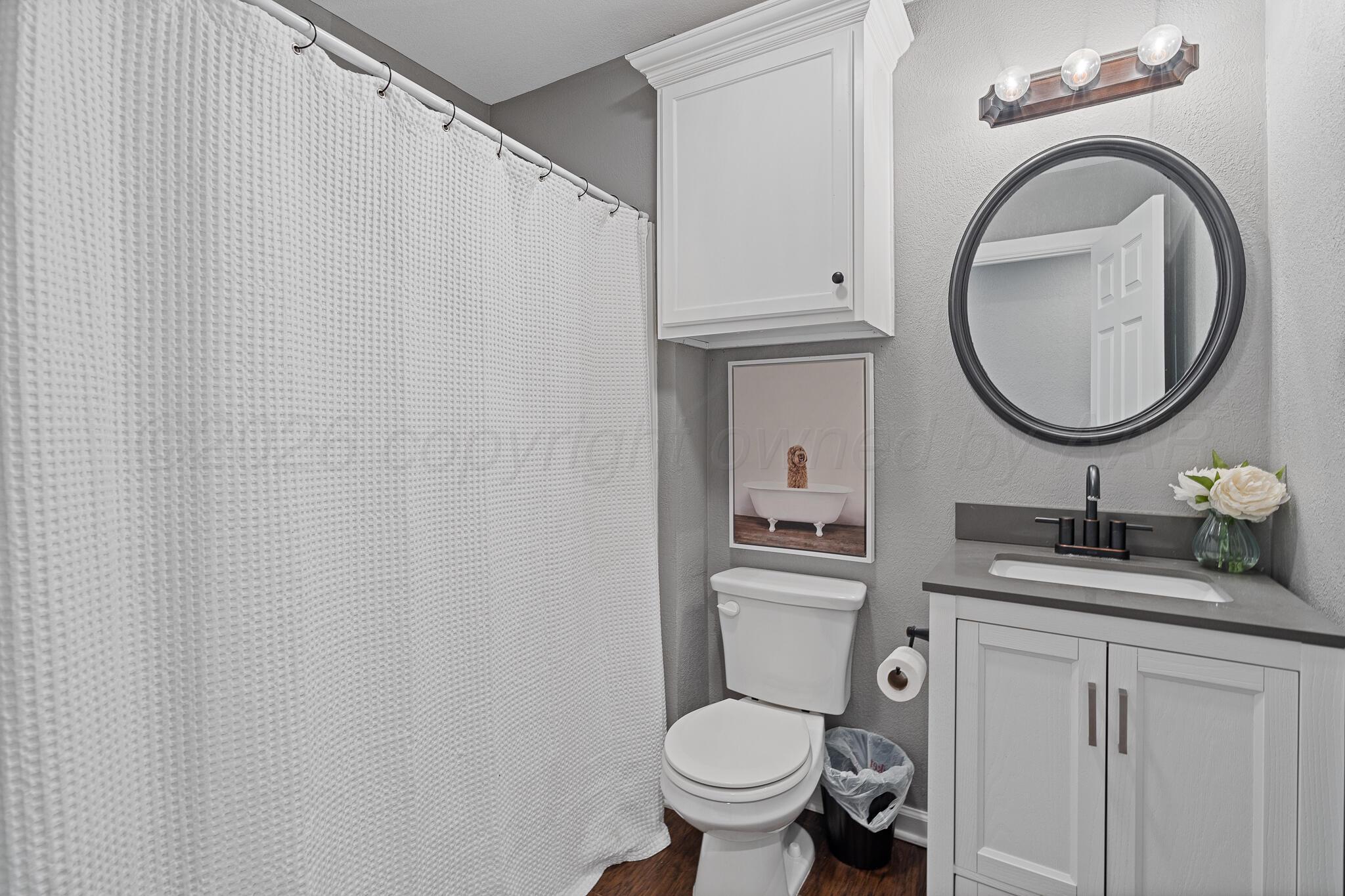 104 South Cherry Street Claude, TX 79019 - Photo 22 of 22 a bathroom with a granite countertop toilet sink and mirror