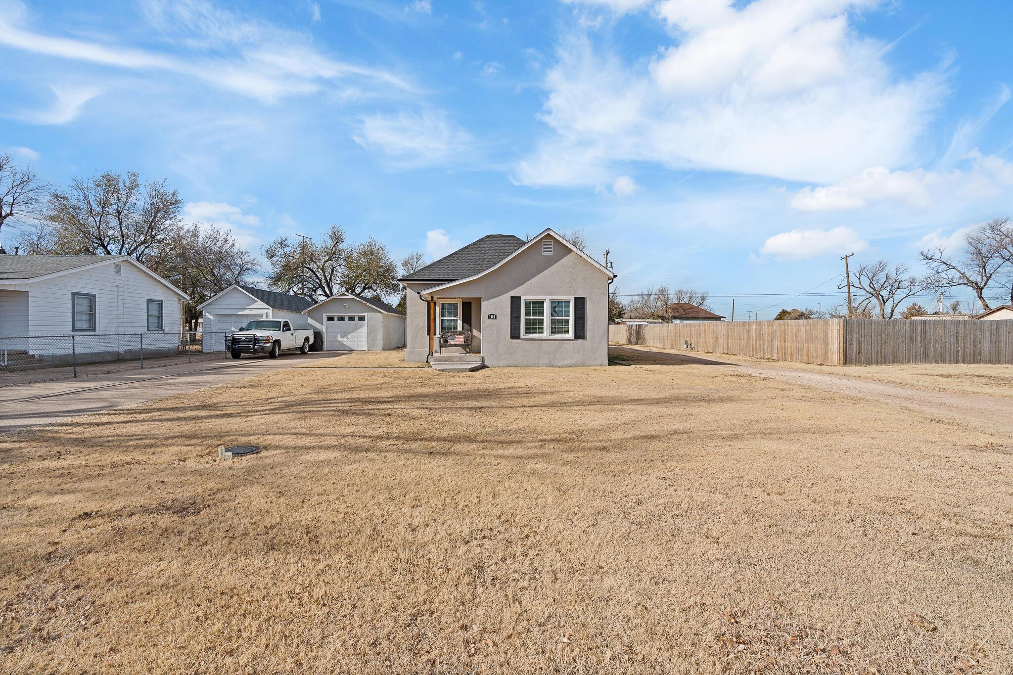 104 South Cherry Street Claude, TX 79019 - Photo 5 of 22 a view of white house with a big yard and large trees