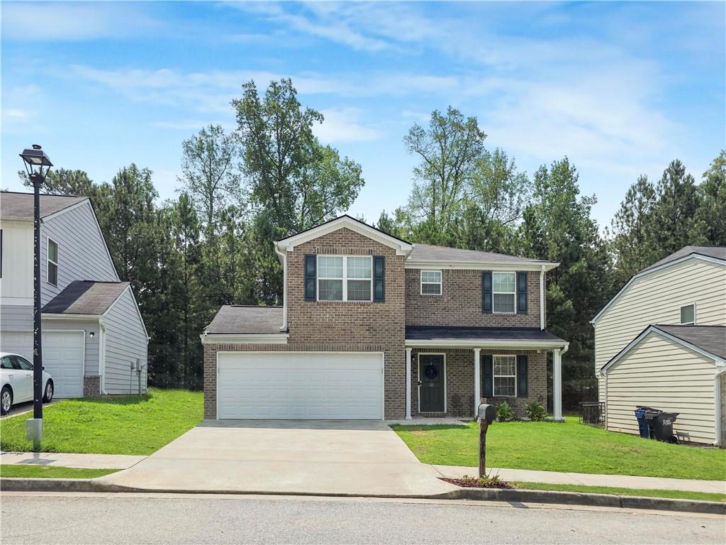 4709 Tradition Parkway, Unit 2 Atlanta, GA 30349 - Photo 1 of 28 a house that has a tree in front of it