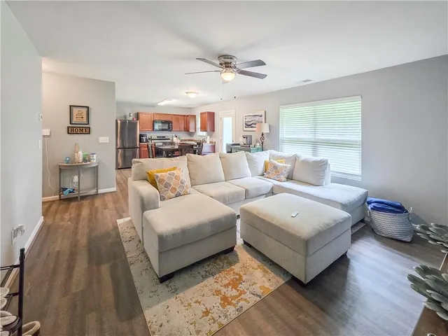 a living room with furniture and a wooden floor