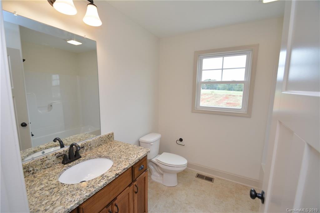 1331 George Brown Road Crouse, NC 28033 - Photo 20 of 39 a bathroom with a granite countertop sink a toilet and a mirror