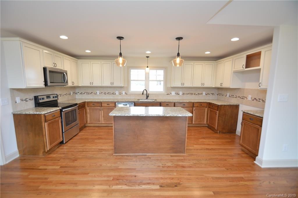 1331 George Brown Road Crouse, NC 28033 - Photo 8 of 39 a large kitchen with kitchen island a sink a stove a counter top space and cabinets