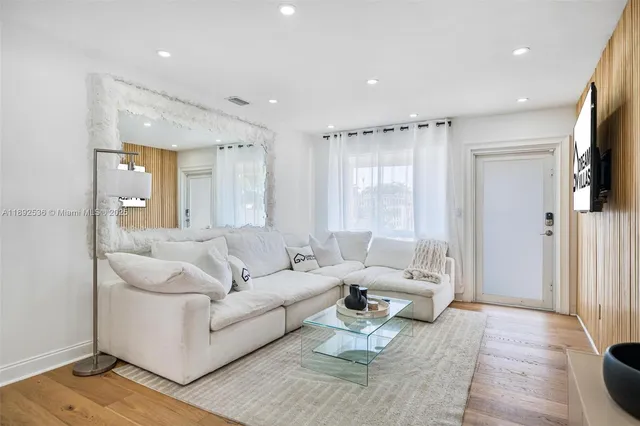a living room with furniture flat screen tv and a large window
