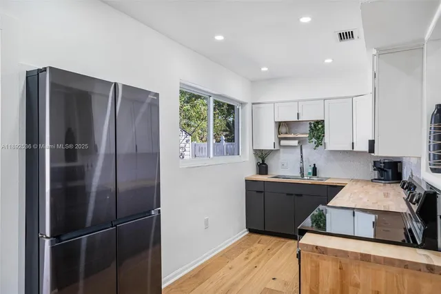 a kitchen with stainless steel appliances granite countertop a refrigerator sink and stove