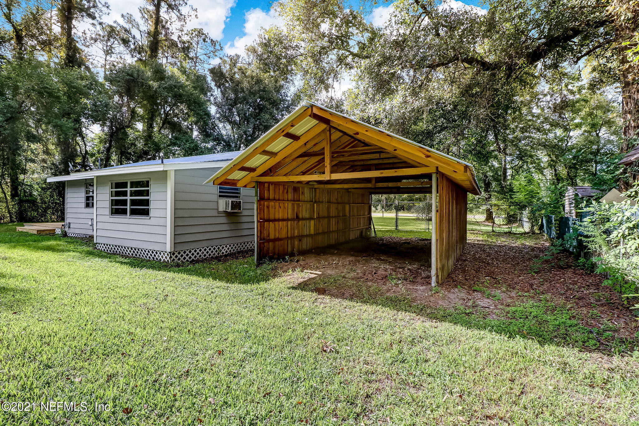541754 Lem Turner Road Callahan, FL 32011 - Photo 26 of 27 a view of a small house with a small yard and large tree