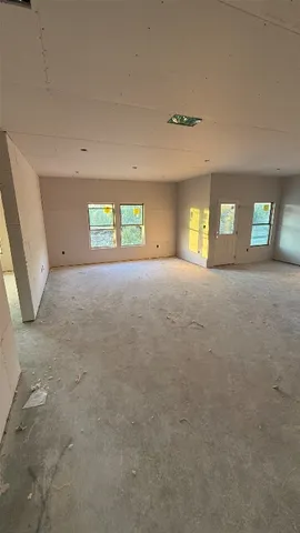 an empty room with a fireplace and windows