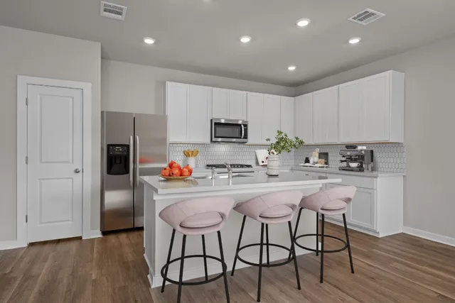 a kitchen with stainless steel appliances granite countertop a refrigerator and a stove top oven