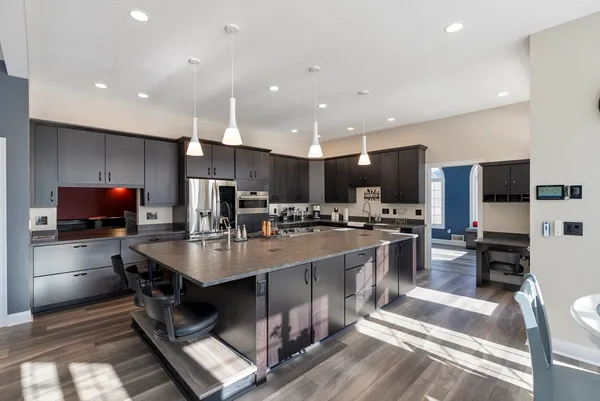 a kitchen with stainless steel appliances kitchen island granite countertop a stove and cabinets
