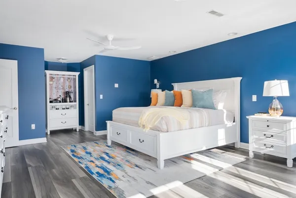 a bedroom with a bed and wooden floor