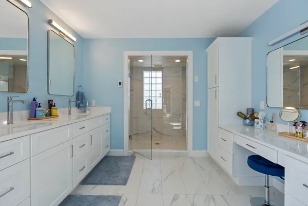 a spacious bathroom with a double vanity sink a mirror and shower