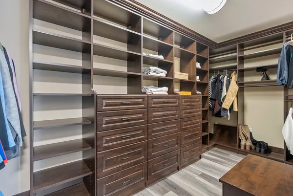 a view of walk in closet with clothes and shoes