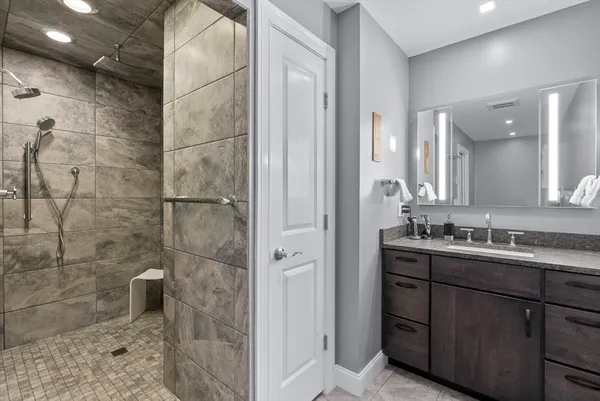 a bathroom with a double vanity sink a toilet and shower