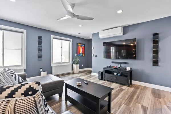 a living room with furniture a flat screen tv and a window