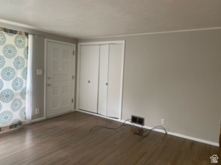 1615 Pioneer Road Draper, UT 84020 - Photo 6 of 13 Entry area featuring wood-finish flooring, a paneled door with brass hardware, and bi-fold closet doors