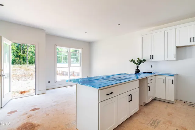 a kitchen with stainless steel appliances granite countertop a refrigerator sink and white cabinets