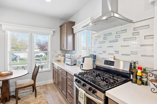 a kitchen with a stove a sink a dining table and chairs