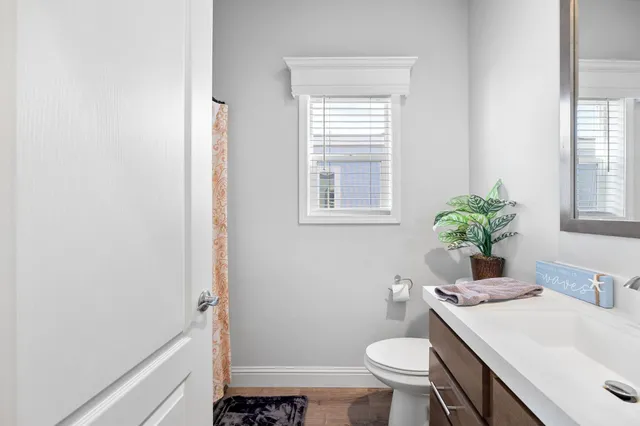 a bathroom with a sink toilet and window