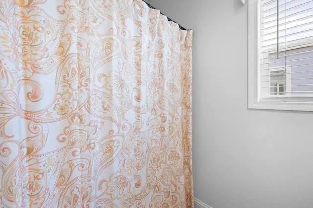 a bathroom with a bathtub and a shower curtain