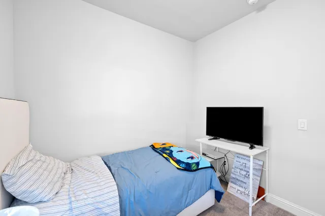 a bedroom with a bed and a flat screen tv