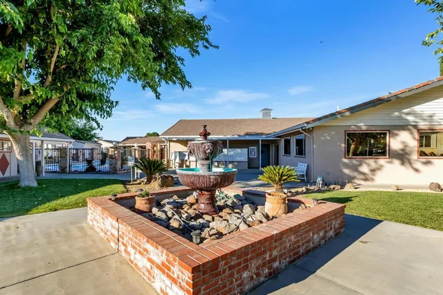 a view of a house with backyard sitting area and garden