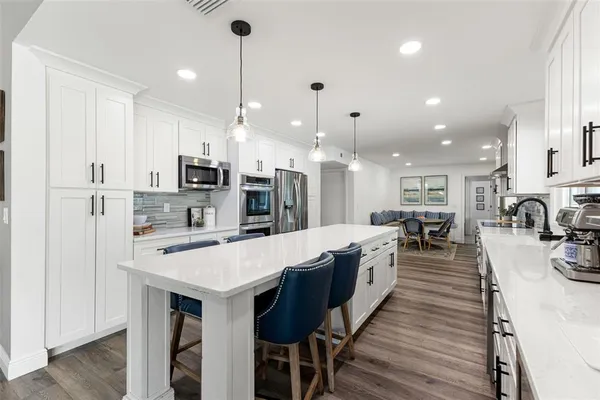 a view of a dining room with furniture a chandelier and wooden floor