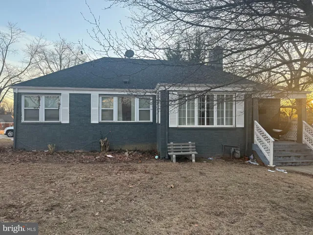 a front view of a house with a yard and an trees