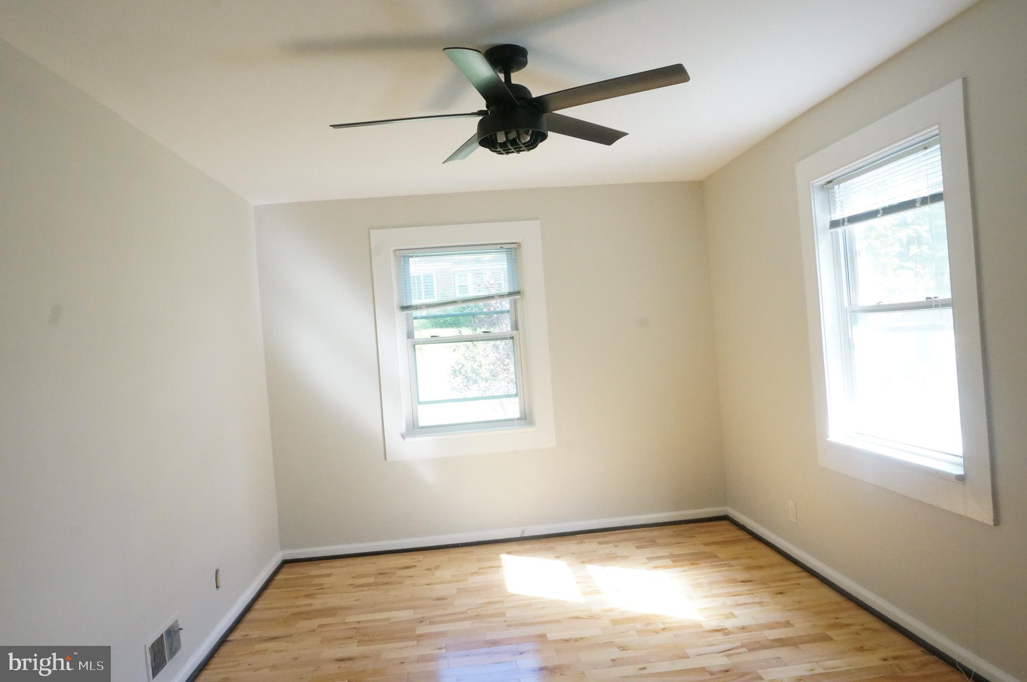 5603 Hawthorne Street Cheverly, MD 20785 - Photo 33 of 88 an empty room with wooden floor ceiling fan and windows
