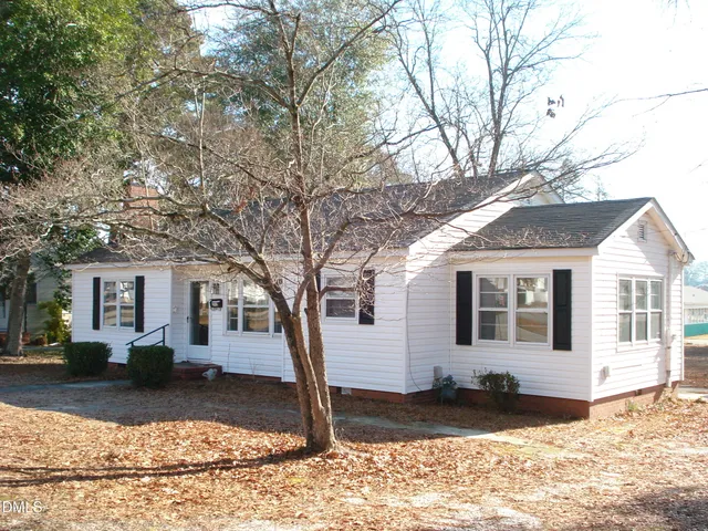 a front view of a house with a yard covered in snow