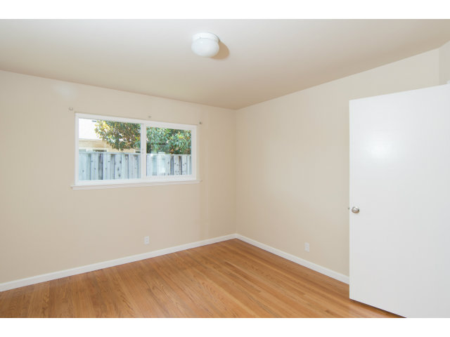 519 Piazza Drive Mountain View, CA 94043 - Photo 8 of 15 an empty room with wooden floor and windows