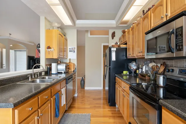 a kitchen with stainless steel appliances granite countertop a sink stove and refrigerator