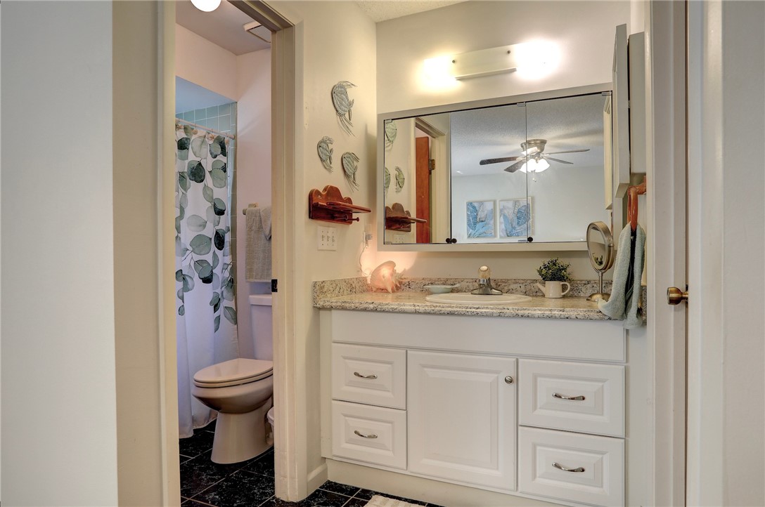 8205 Capewell Court Sebastian, FL 32958 - Photo 12 of 25 a bathroom with a granite countertop sink a toilet and a mirror