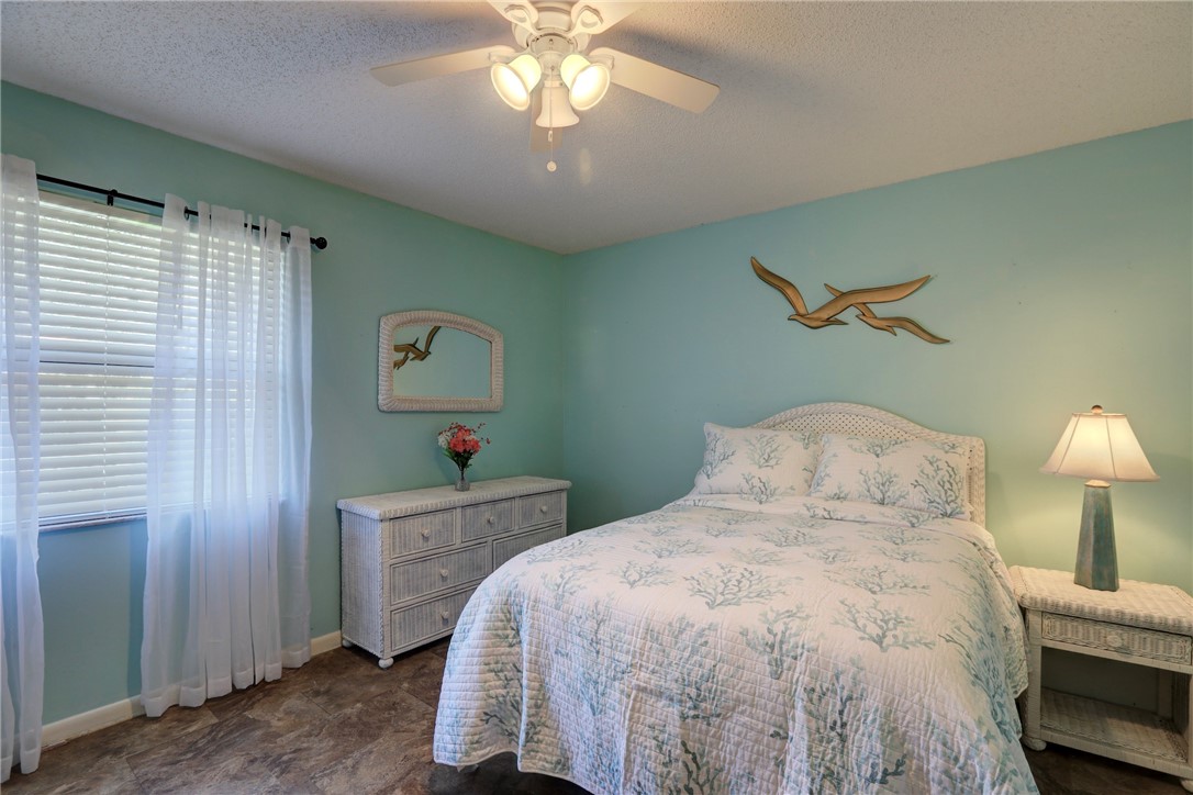 8205 Capewell Court Sebastian, FL 32958 - Photo 13 of 25 a bedroom with a bed and a chandelier