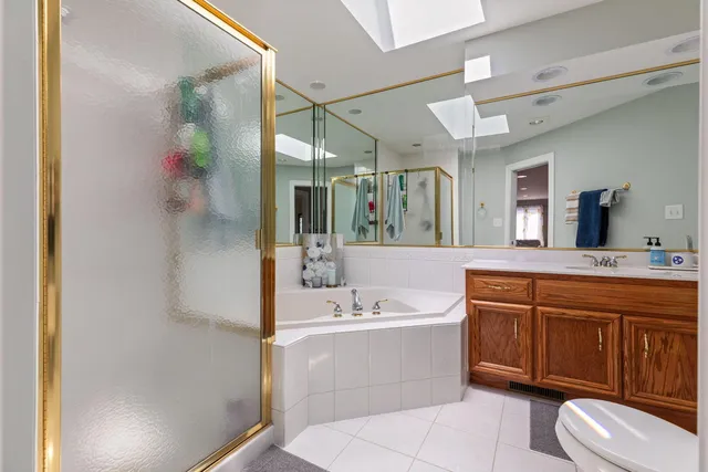 a bathroom with a tub sink mirror and toilet