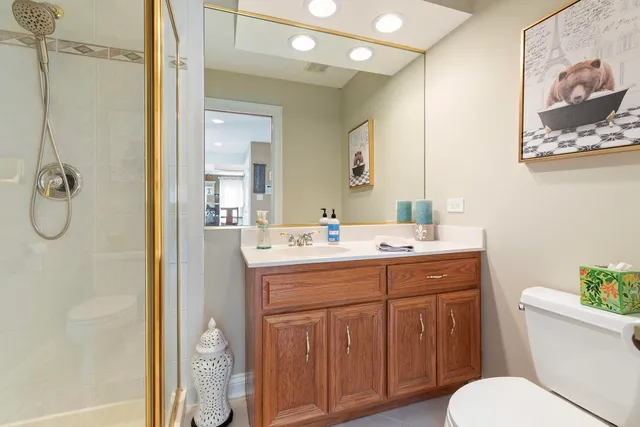 a bathroom with a granite countertop sink toilet and shower