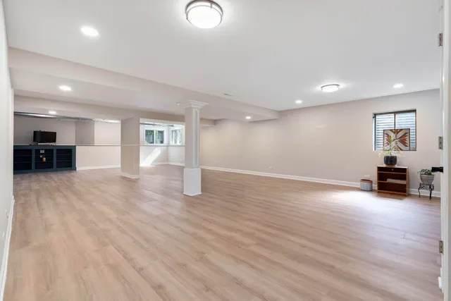 a view of empty room with wooden floor and furniture