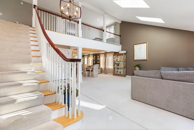 a livingroom with furniture staircase and a floor to ceiling window
