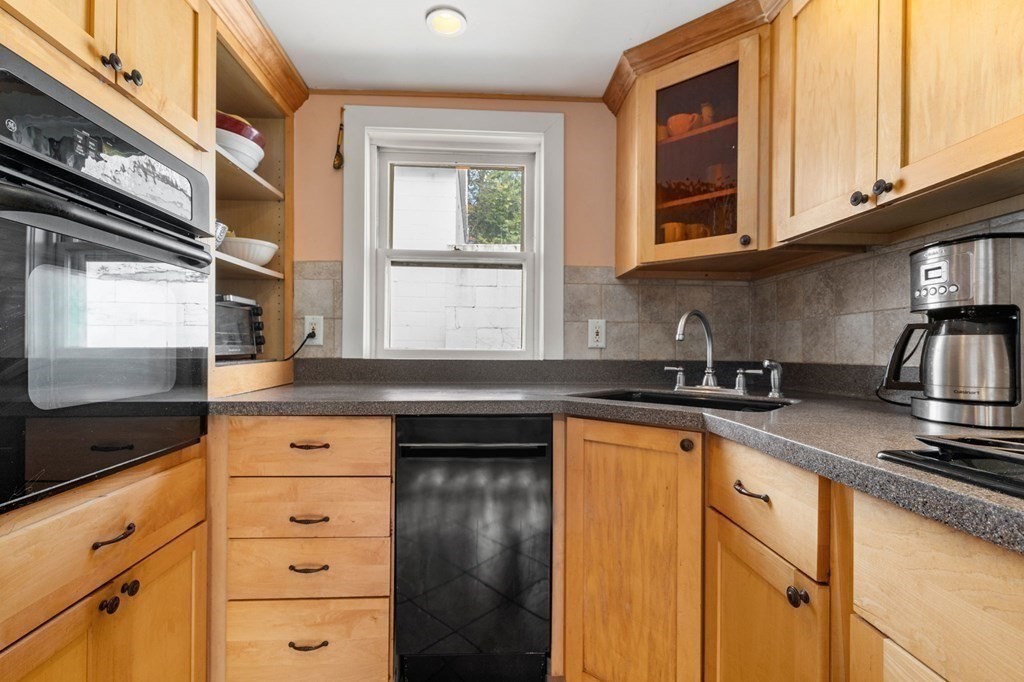 12 Spring Street Newton, MA 02464 - Photo 13 of 42 a kitchen with stainless steel appliances granite countertop a sink stove and cabinets