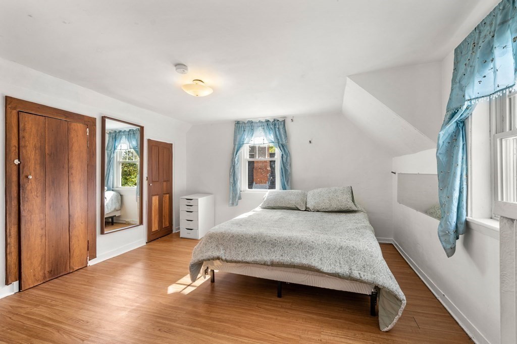 12 Spring Street Newton, MA 02464 - Photo 33 of 42 a bedroom with a large bed and a chandelier