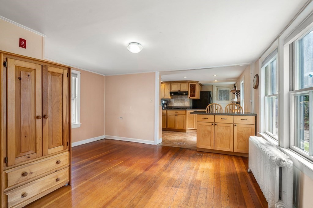 12 Spring Street Newton, MA 02464 - Photo 7 of 42 a kitchen with granite countertop a refrigerator and wooden floor