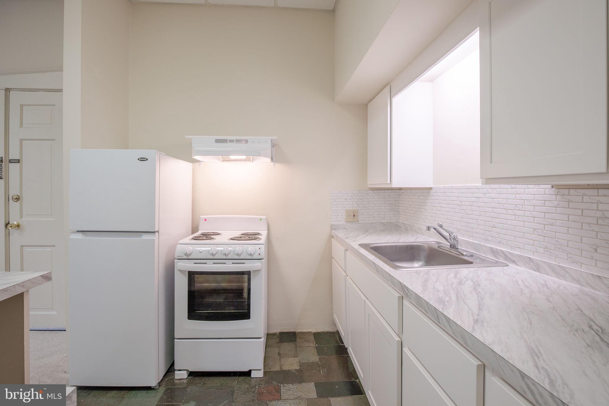 109 North Lime Street, Unit 2 Lancaster, PA 17602 - Photo 14 of 22 a kitchen with granite countertop white cabinets and white appliances