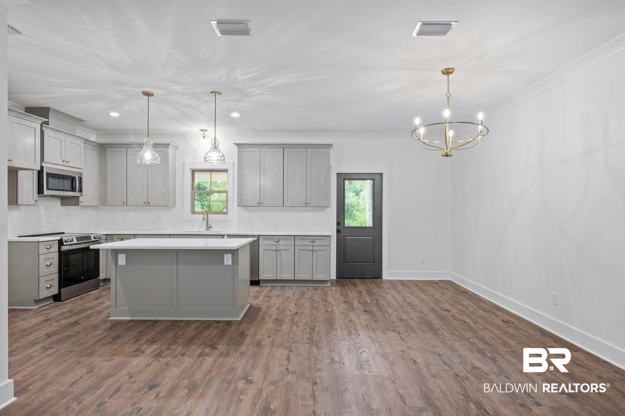 12412 Mannich Lane Foley, AL 36535 - Photo 5 of 23 Kitchen with stainless steel appliances, gray cabinets, dark wood-type flooring, and decorative light fixtures